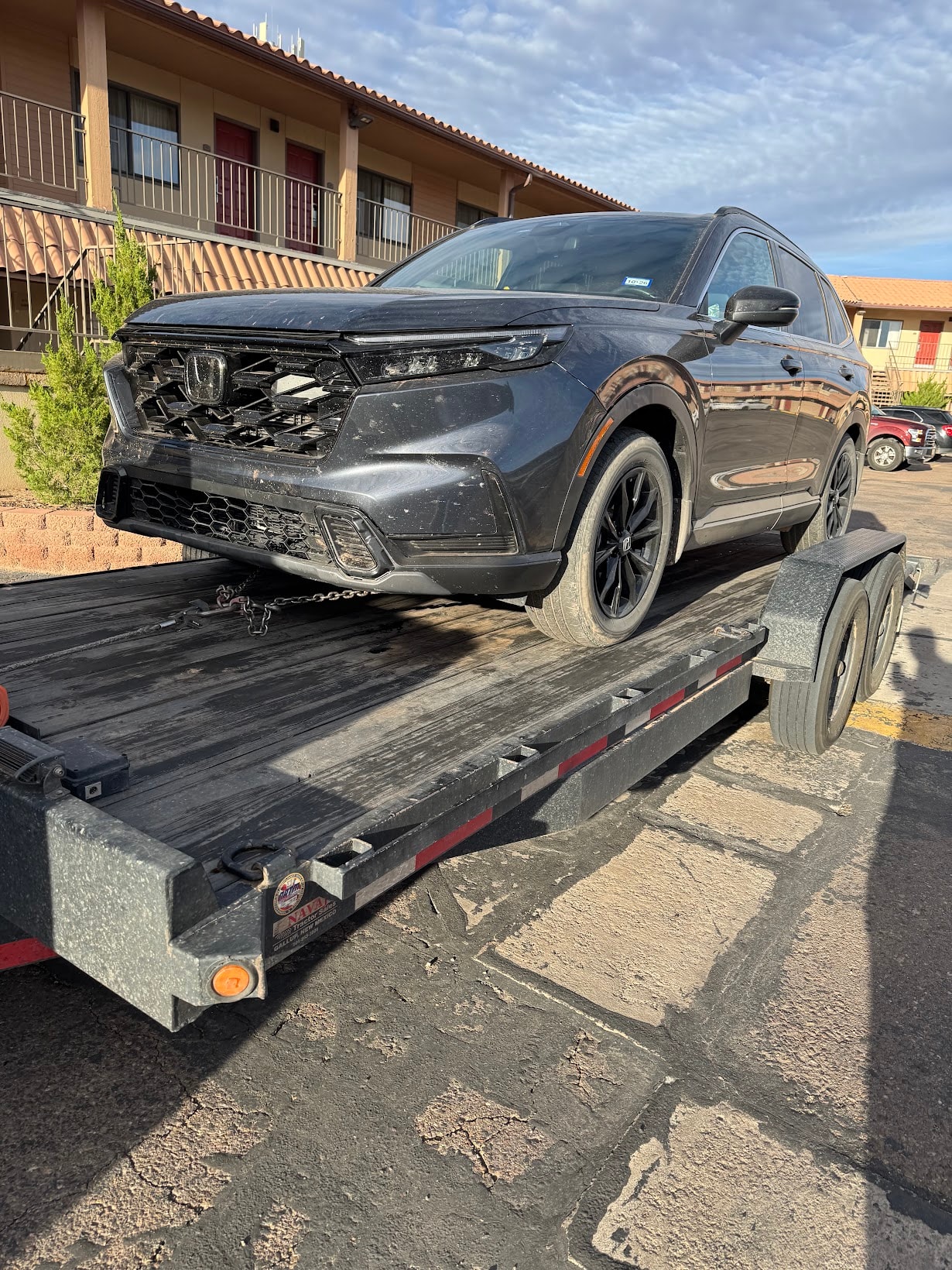 Balaji's damaged Honda CR-V loaded on the Rez Auto flatbed trailer outside a hotel in Albuquerque